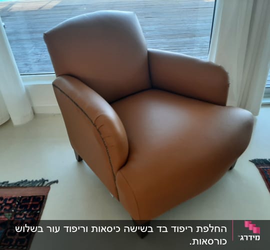 כורסה מרופדת חומה עם רגליים כהות